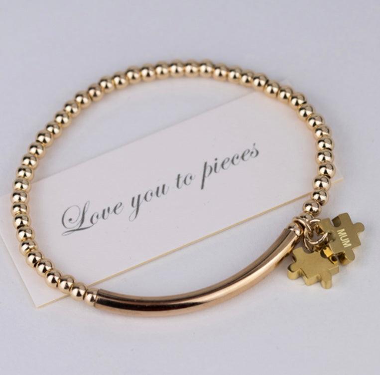 Gold beaded bracelet with two jigsaw shaped charms with personalised initials engraving And card saying I love you to pieced
